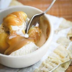 Butterscotch sauce on vanilla ice cream, with spoon digging in.