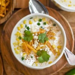 a small bowl of Mexican street corn chowder topped with all the fixings.