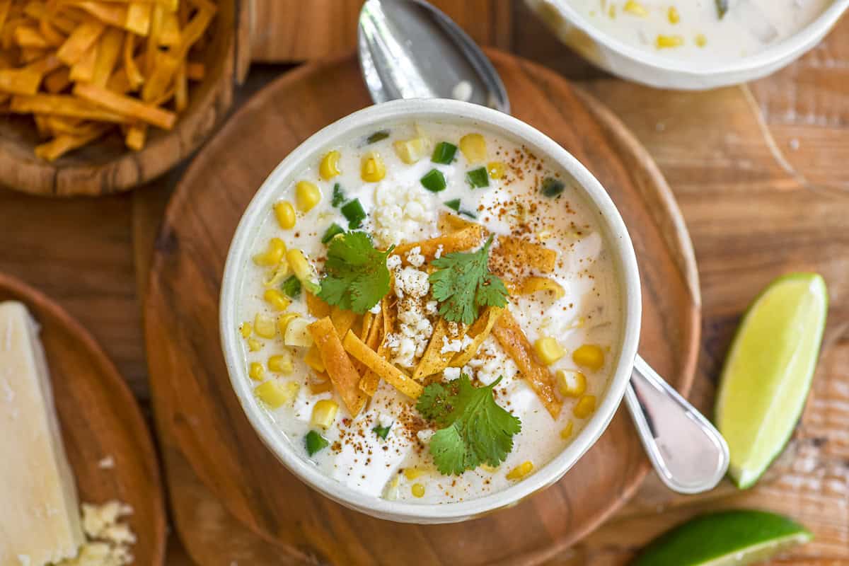 a small bowl of Mexican street corn chowder topped with all the fixings.