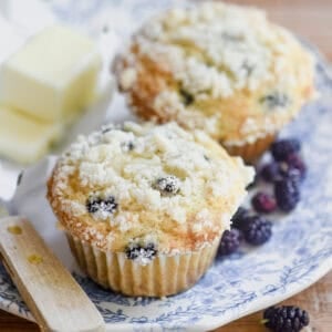 Mulberry muffins on a plate with butter and knife.