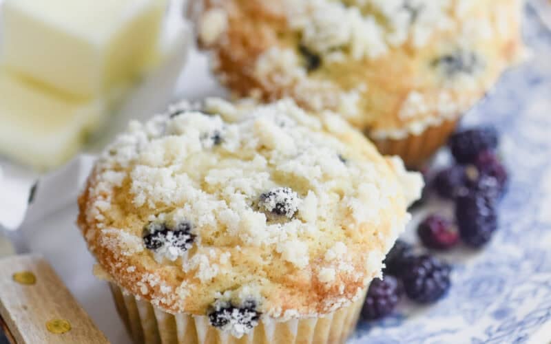 Mulberry muffins on a plate with butter and knife.