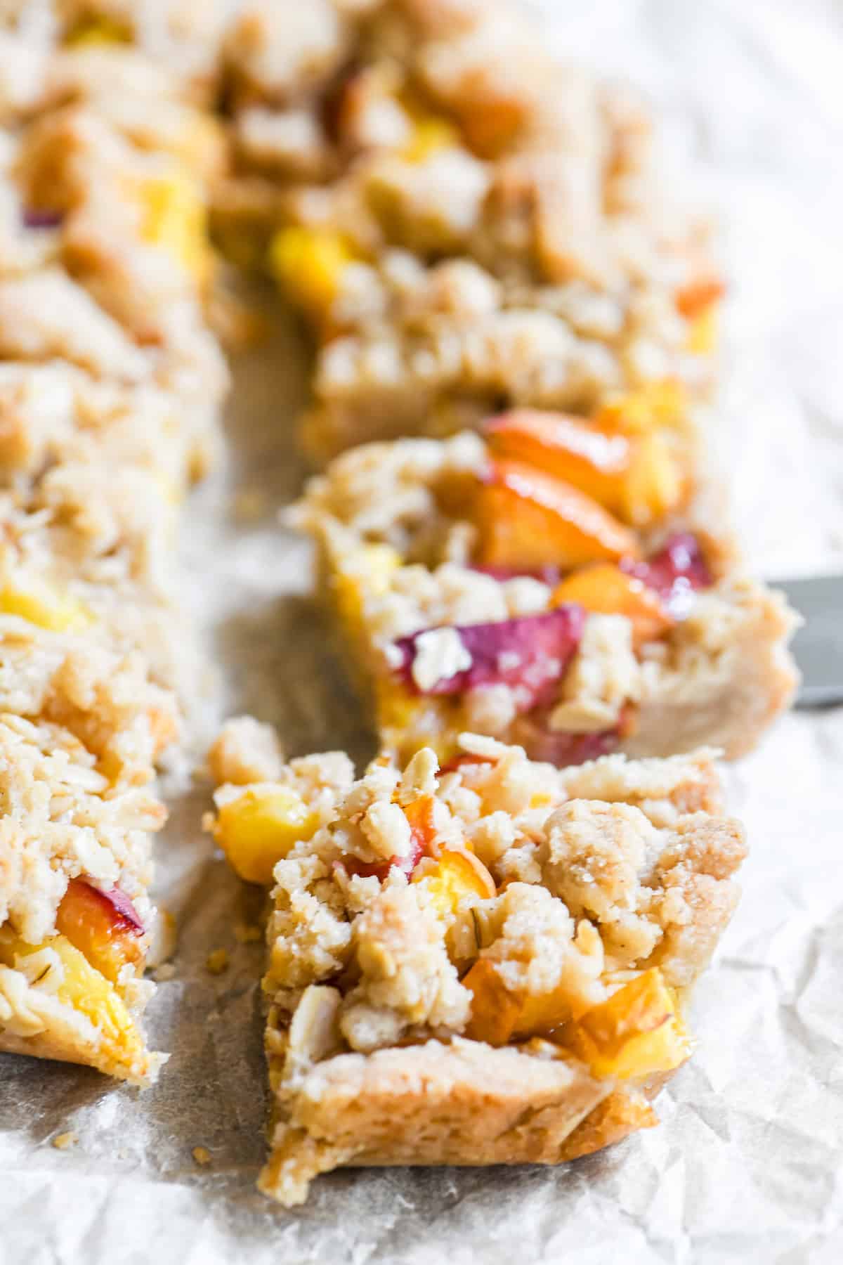spiced peach cobbler bars, sliced on a sheet of parchment paper.