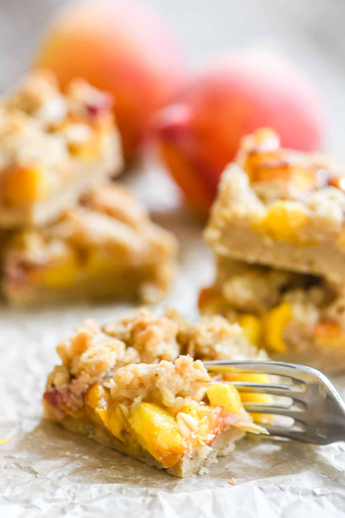 Spiced peach cobbler bars, sliced into bars with fork taking a bite.