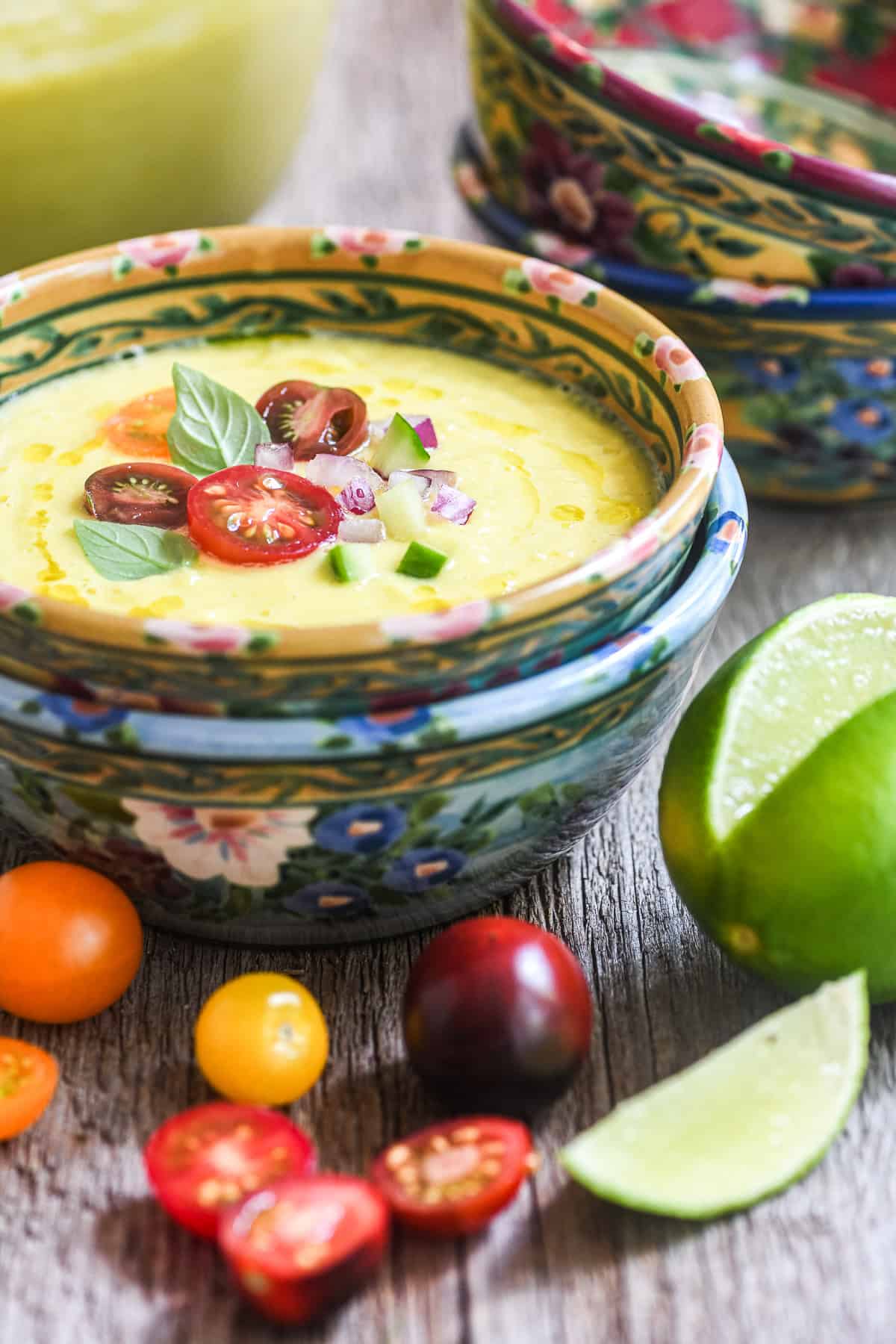 bright yellow sweet corn gazpacho in stoneware bowls.