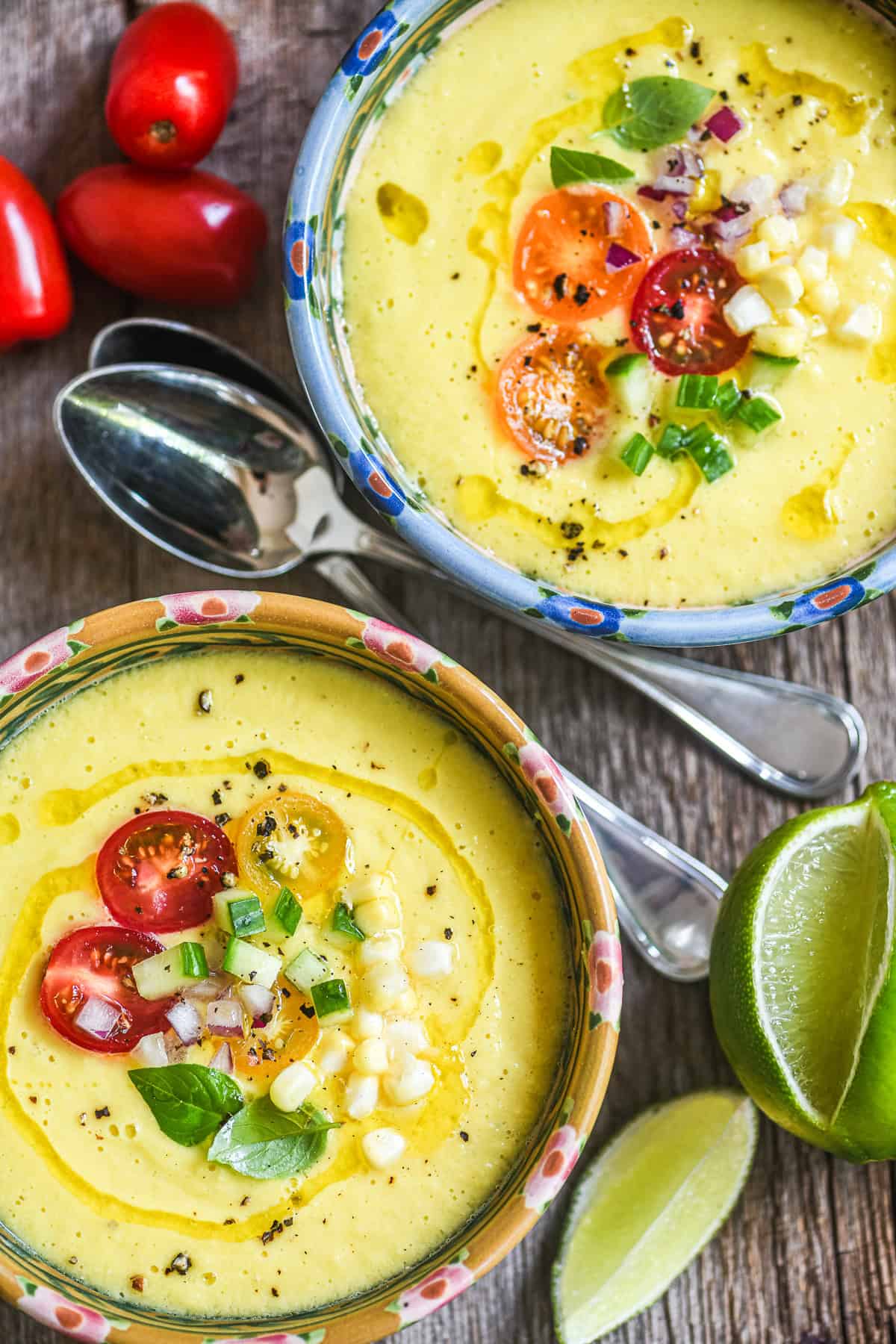 2 bowls of sweet corn gazpacho, topped with cherry tomatoes and baby basil leaves.