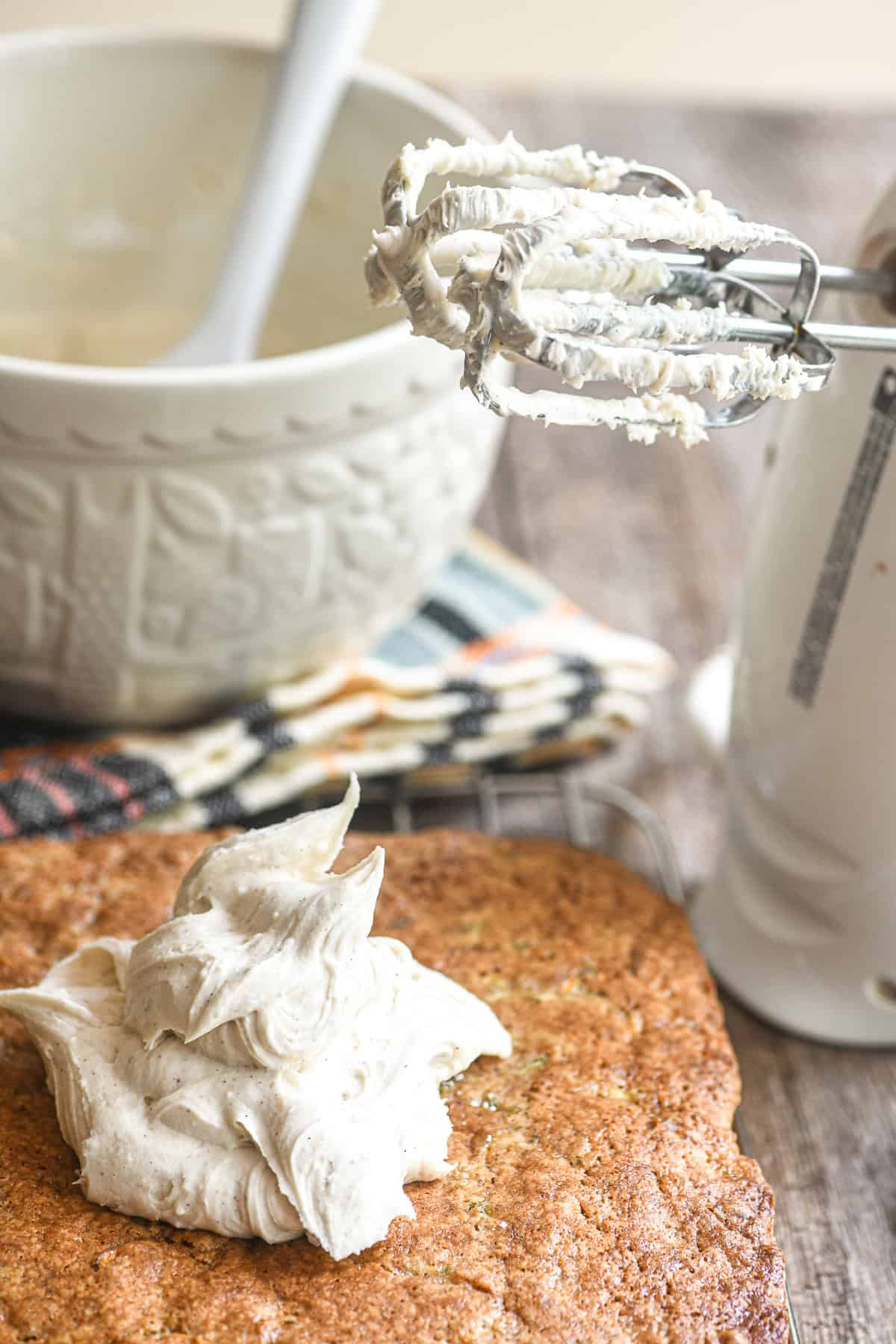 Browned butter frosting dolloped on a zucchini snack cake.