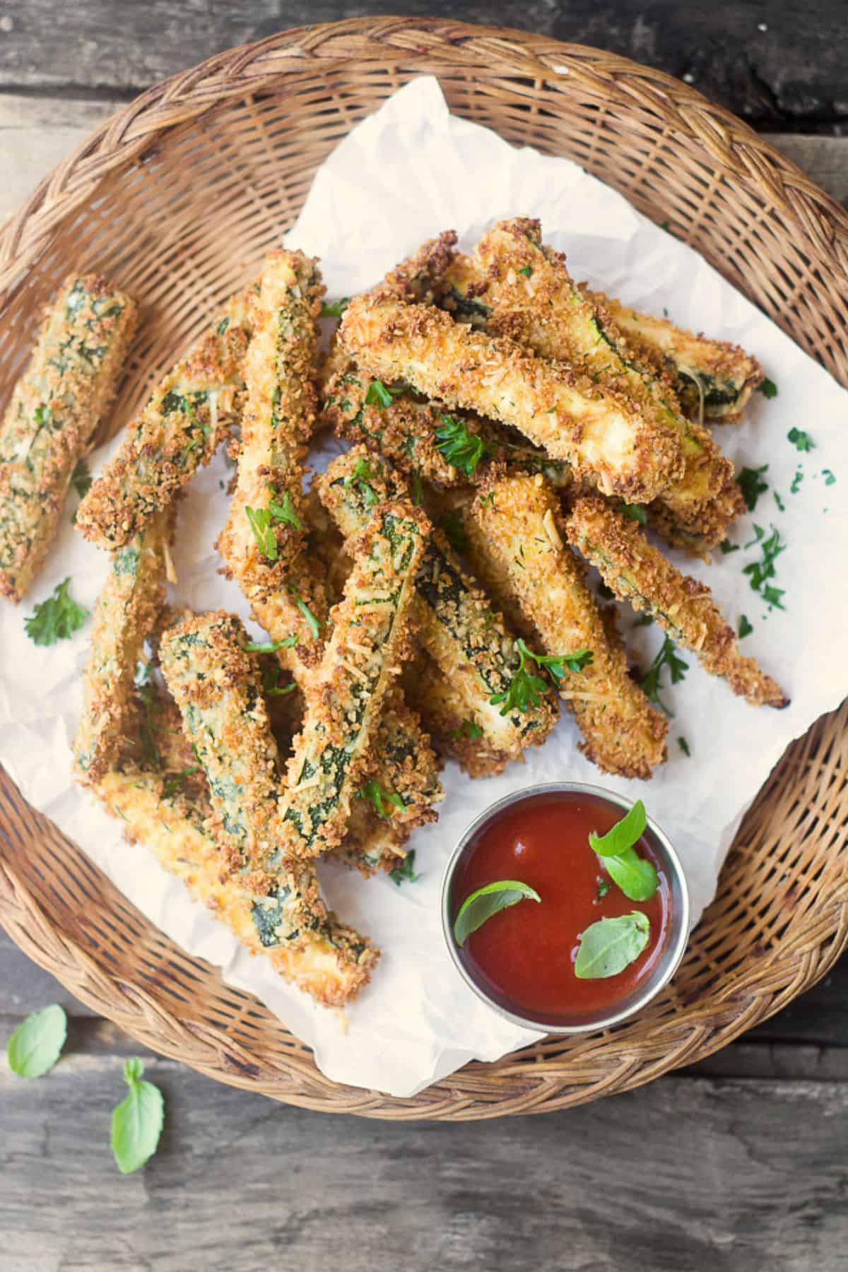 a plate of baked zucchini fries with dipping sauce.
