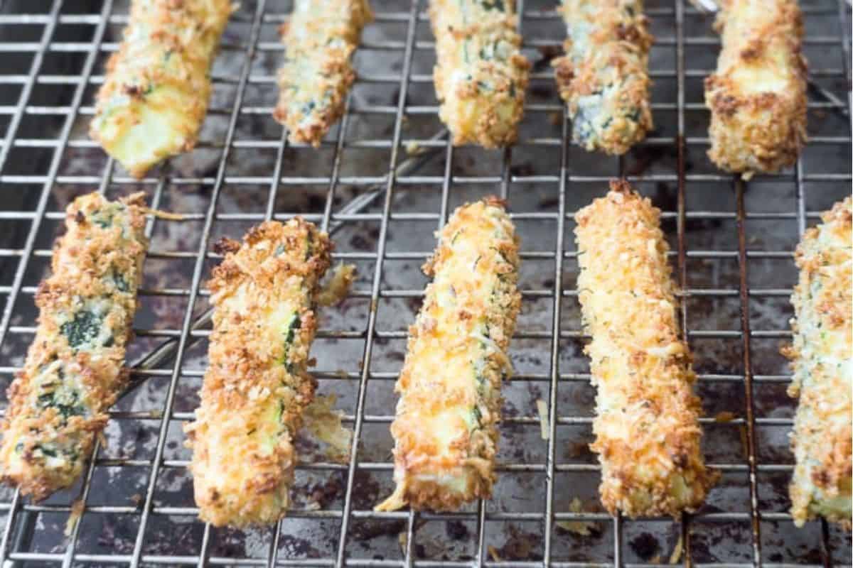 Baked zucchini fries cooling on a rack.