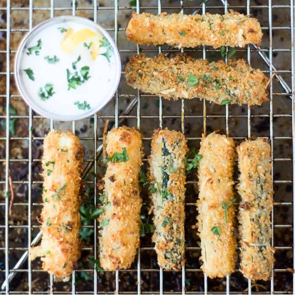baked zucchini fries on a rack.