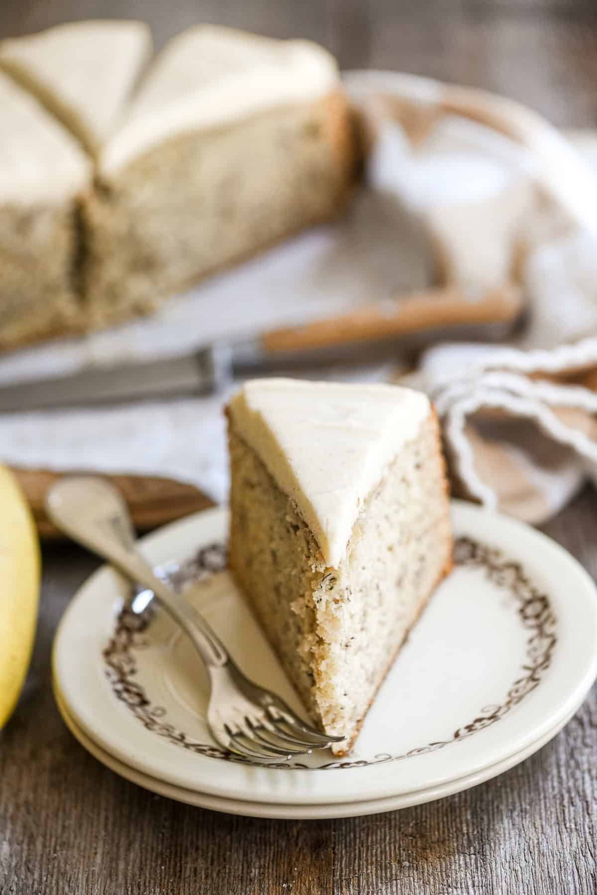A slice of banana cake with spiced mascarpone frosting, on a plate.