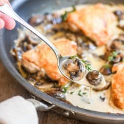 spooning sauce from a pan of chicken thighs Marsala.