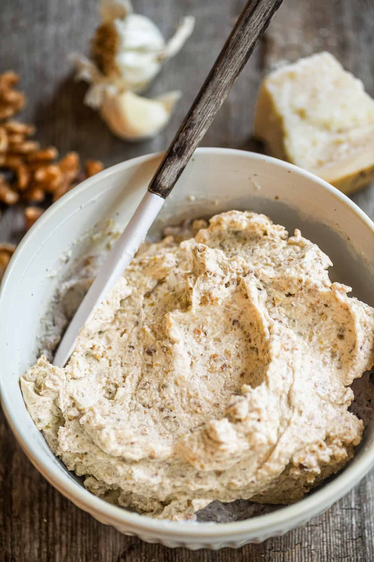 Italian walnut sauce in a bowl with walnuts, garlic, and Parm.