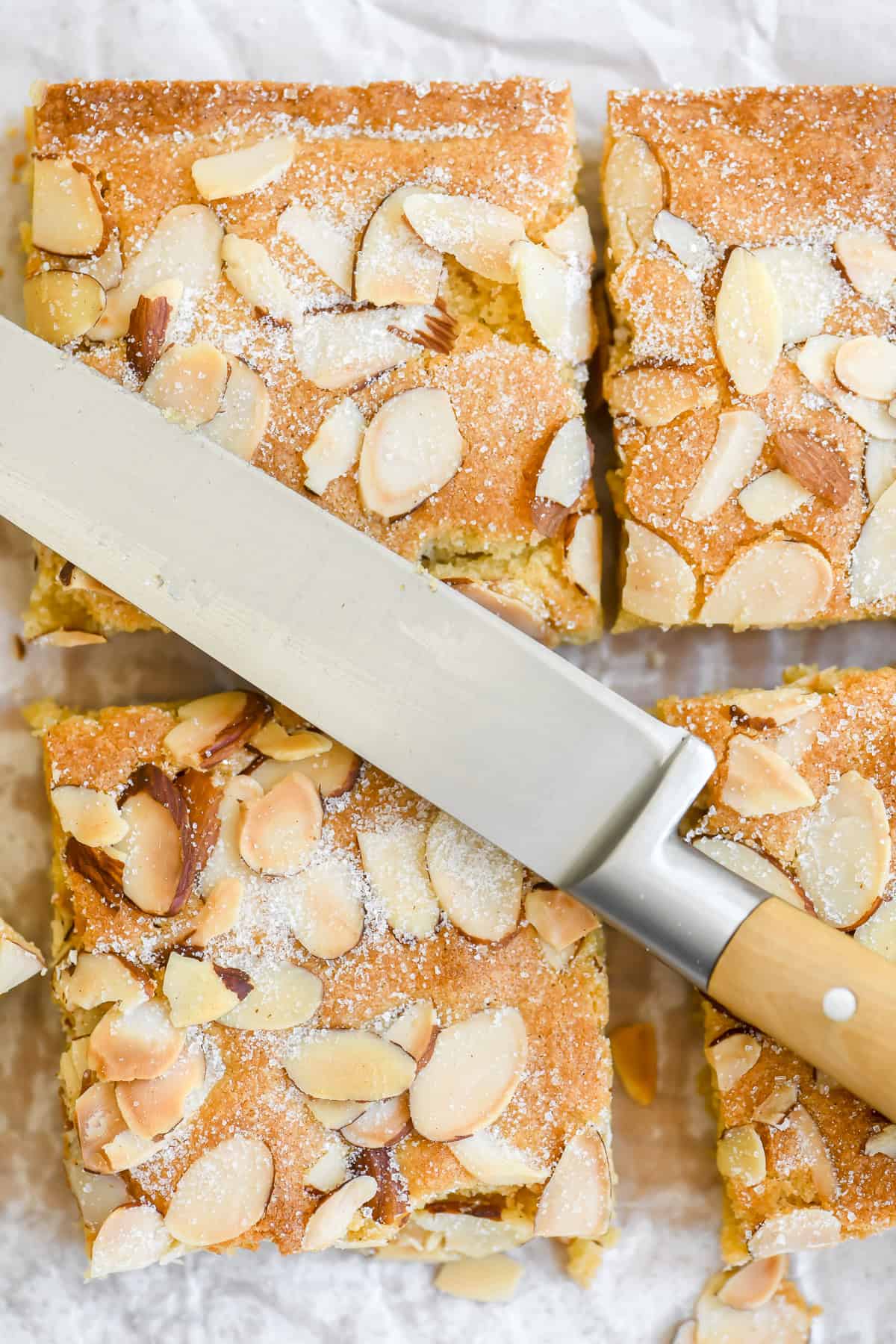 Almond brownies topped with sliced almonds, cut into squares.