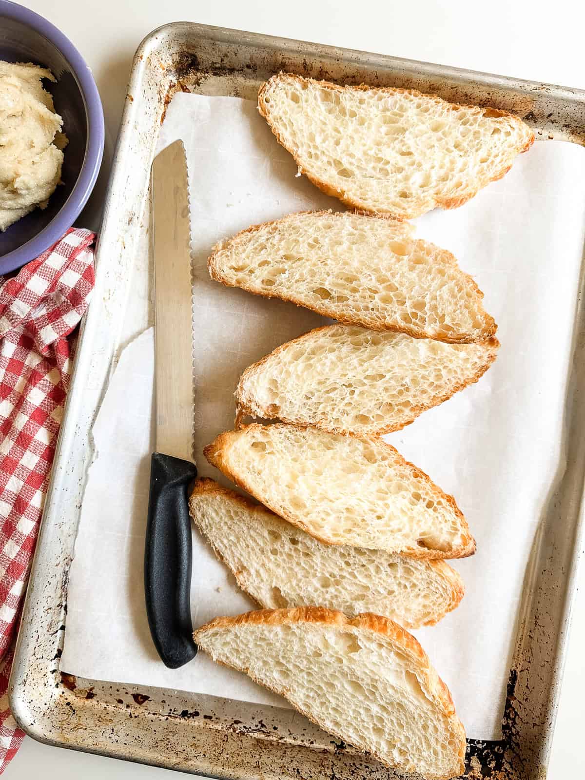 Spreading almond frangipane filling onto toasted croissants.