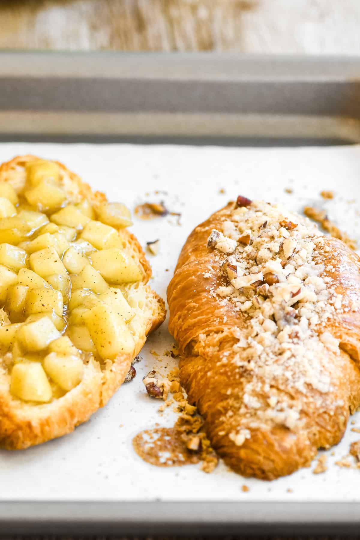 Apple pie twice baked croissants on a baking sheet.