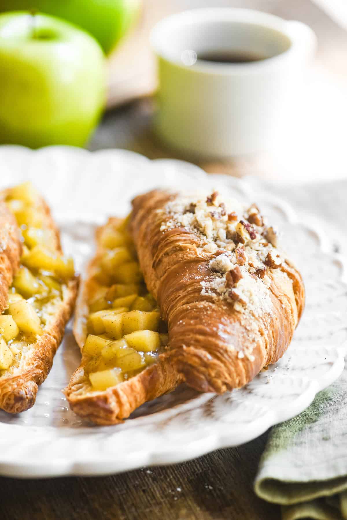 Twice baked croissants with apple pie filling, on a brunch table with coffee.