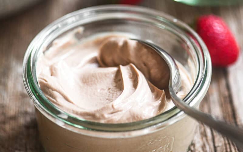 A small jar of chocolate hazelnut yogurt with spoon.