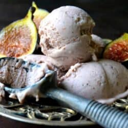 scoops of fig gelato in a bowl with fresh figs.