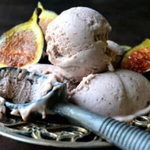 scoops of fig gelato in a bowl with fresh figs.