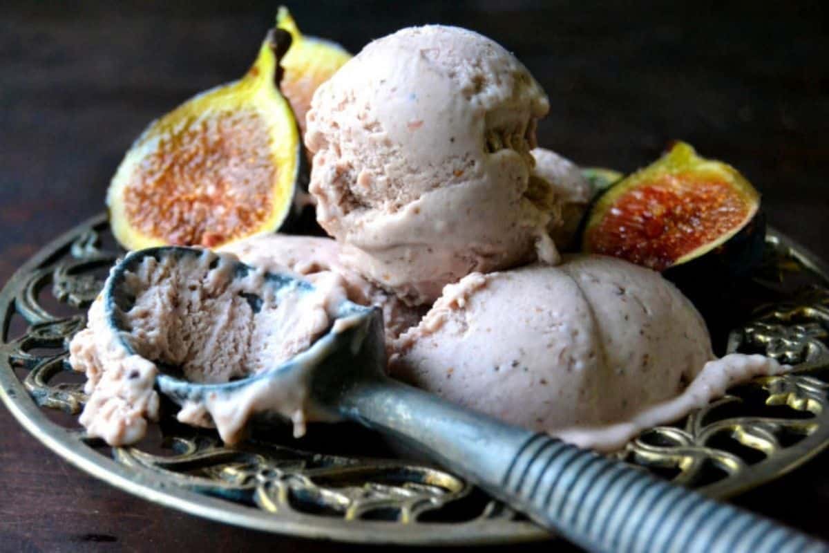 scoops of fig gelato in a bowl with fresh figs.