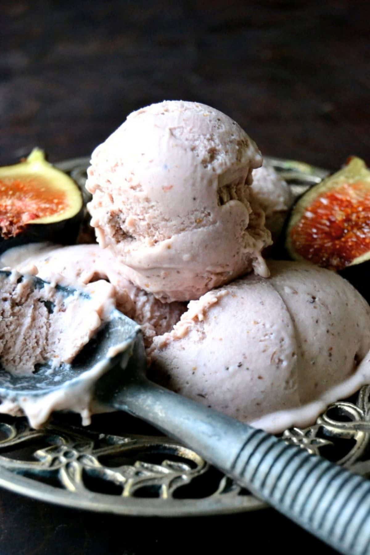 Creamy fig gelato, in a bowl with vintage ice cream scoop.