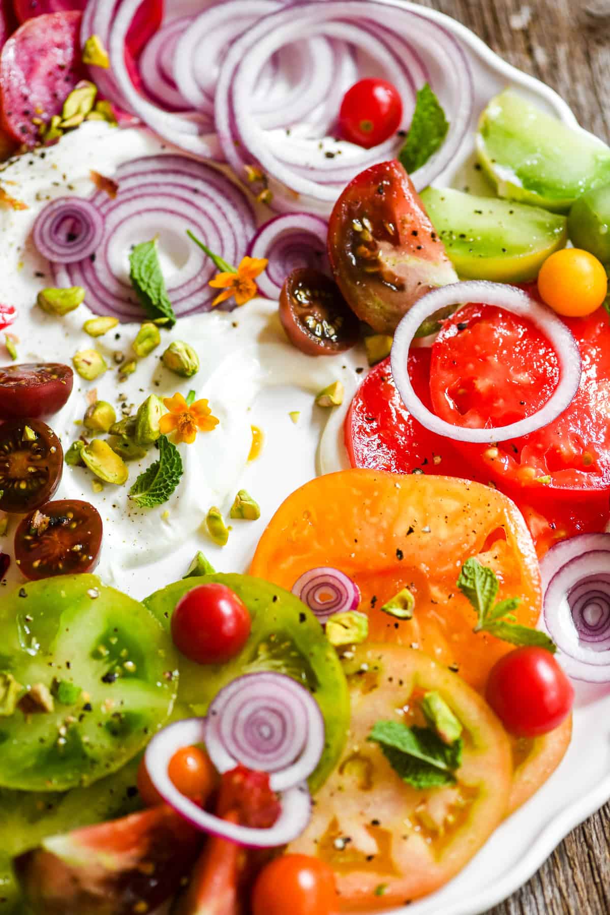 tomato and beet composed salad surrounding whipped goat cheese.