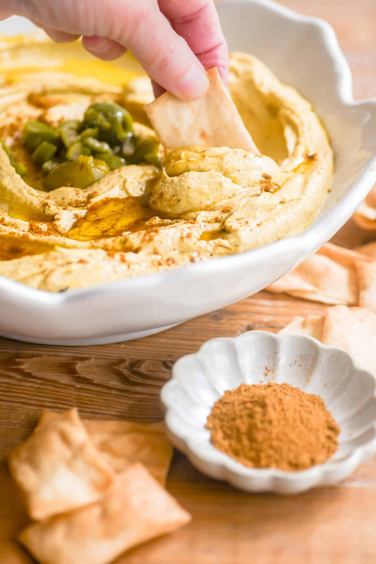 Dipping a toasted pita chip into Moroccan hummus.