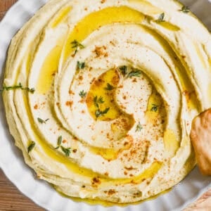 overhead look at a bowl of Moroccan hummus topped with a dusting of ras el hanout.