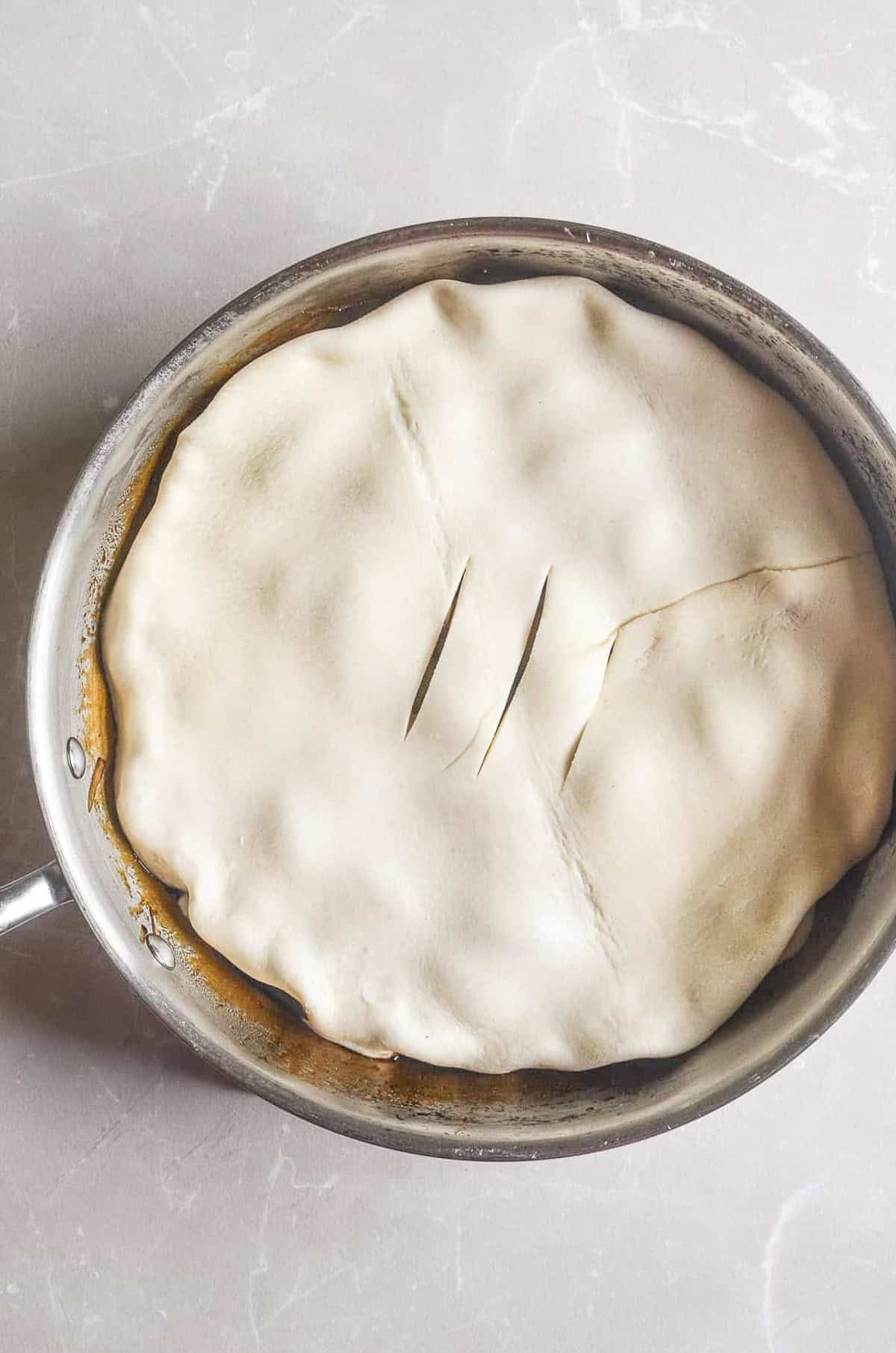 Puff pastry crust on caramelized shallot tarte tatin, read for the oven.