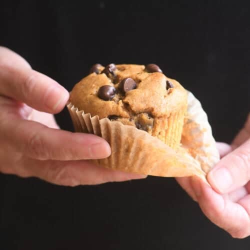 Pulling back the wrapper on a chocolate chip pumpkin muffin.