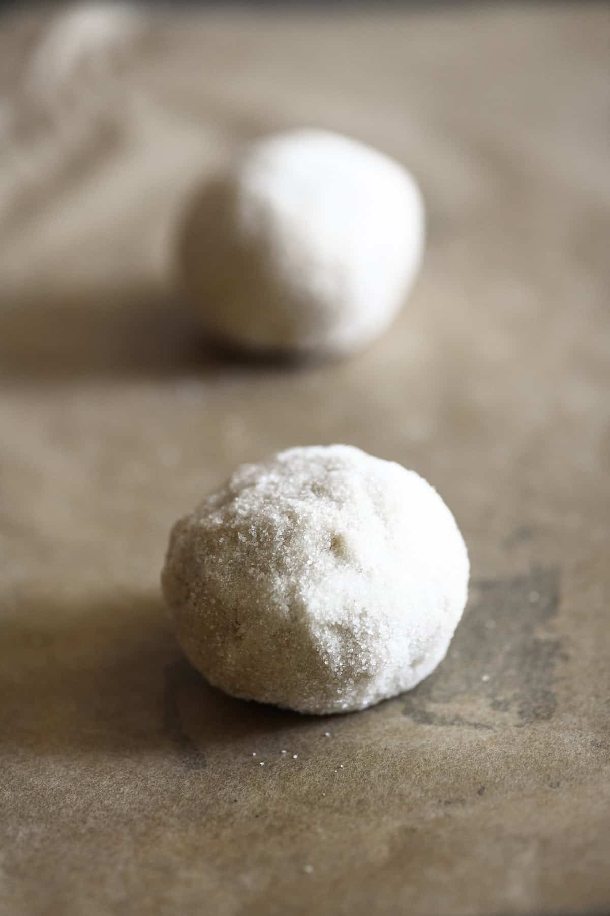 Balls of Swedish almond cardamom cookie dough coated in sugar.