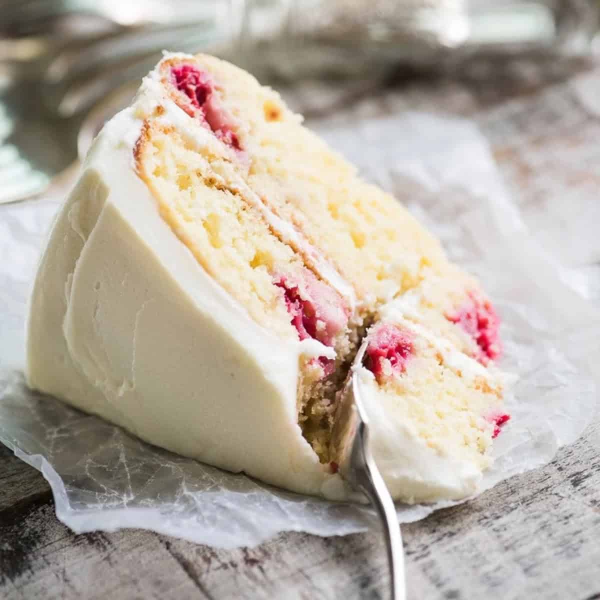 taking a first bite of a slice of raspberry lemon cake.