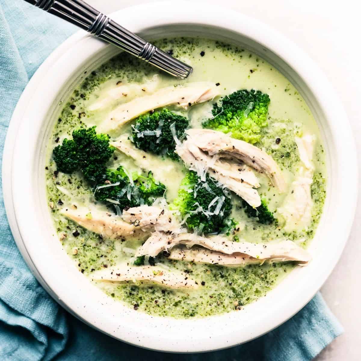 A bowl of high protein and high fiber broccoli cheese soup with blue napkin.