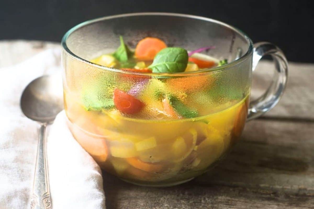 slimming detox vegetable soup in a clear mug.