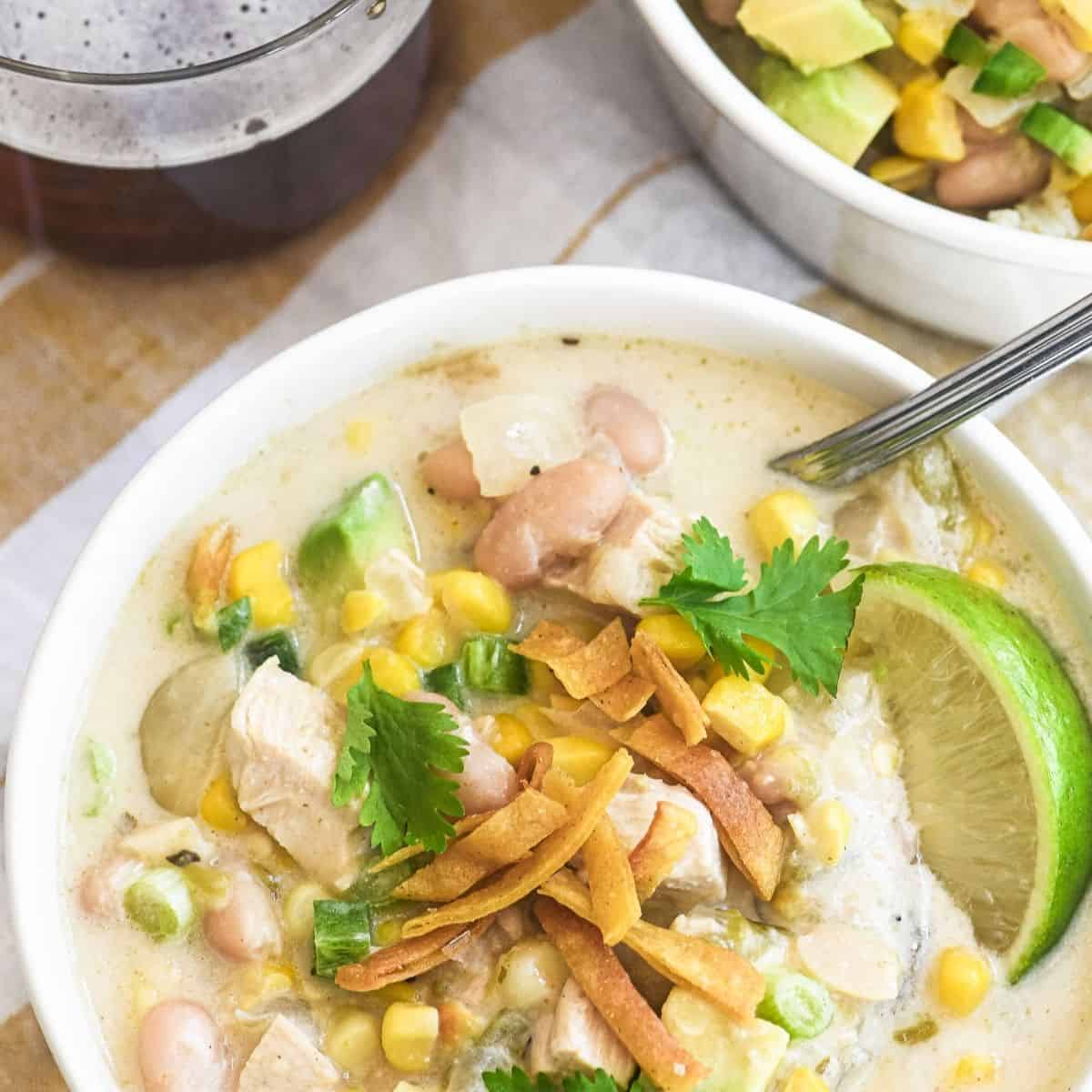 a bowl of protein rich white chicken chili with crispy tortilla chips and lime.